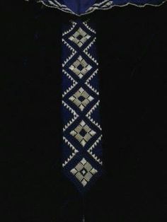 the necktie is blue and white with an intricate design on it's side