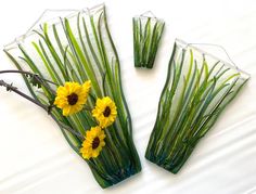 three glass vases with yellow flowers in them