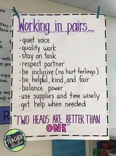 a sign hanging from the side of a wall that says working in pairs with other words