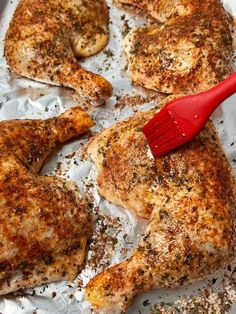 the chicken is covered in seasoning and has a red spatula on top of it