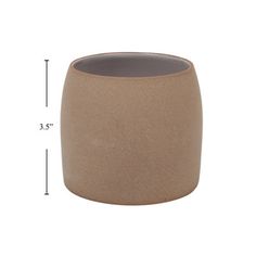 a large brown vase sitting on top of a white table next to a measuring ruler