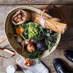 a basket filled with lots of different types of food on top of a wooden table