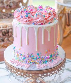 a pink cake with sprinkles and frosting