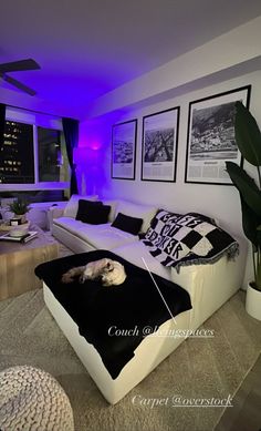 a living room with white furniture and purple lighting on the ceiling is decorated in black and white