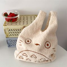 a white bunny bag sitting on top of a table next to strawberries and a basket