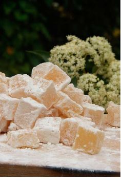 a pile of sugar cubes sitting on top of a table next to some flowers
