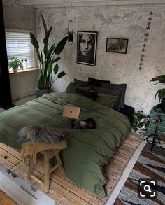 a bedroom with a bed made out of pallet wood and plants on the wall