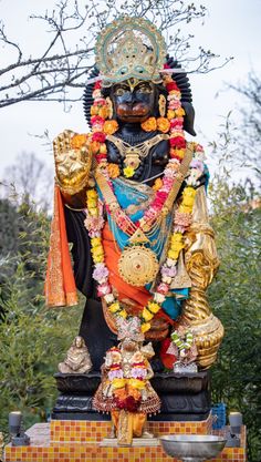 the statue is decorated with flowers and garlands
