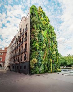 a building covered in green plants on the side