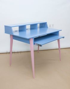 a blue desk with pink legs and two shelves