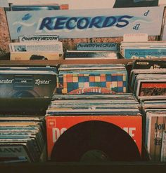 an assortment of records are on display in front of a record player's booth