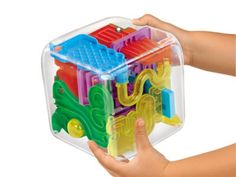 a child's hand is holding a plastic building block set in its storage container