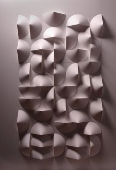 an abstract wall sculpture made out of paper circles and rectangles on the wall