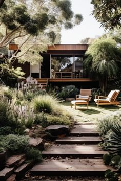 a garden with wooden steps leading up to a house surrounded by trees and plants,