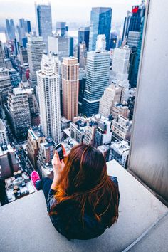 a woman taking a photo from the top of a building