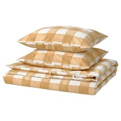 three pillows stacked on top of each other in front of a white background with brown and white checkered pattern