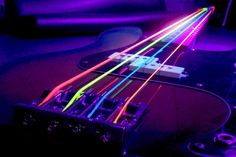 an electric guitar with neon strings in the dark