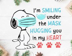 a snoopy dog wearing a face mask with the words i'm smiling under the mask hugging you in my heart