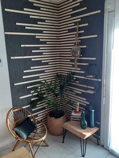 a room with a plant and some decorations on the wall next to a chair in front of it