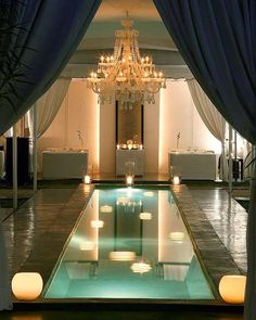 an indoor pool surrounded by candles and curtains