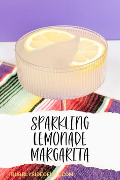 a lemonade margarita sitting on top of a colorful table cloth with the words sparkling lemonade margarita