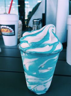 an ice cream sundae with blue and white swirls in a glass cup on a table