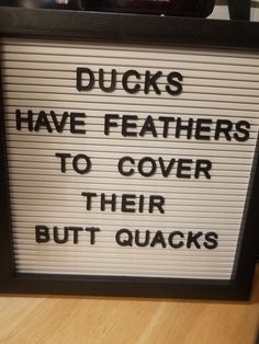 there is a sign that says ducks have feathers to cover their butts on the table