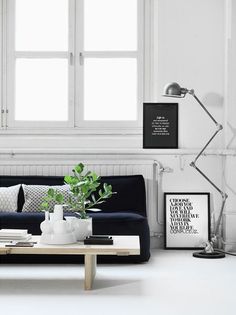 a black and white living room with plants on the coffee table in front of it