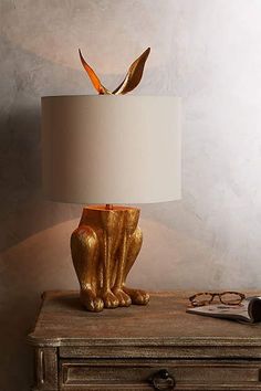 a lamp that is sitting on top of a table next to a pair of glasses