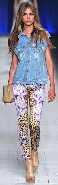 a model walks down the runway wearing blue denim jacket and leopard print leggings