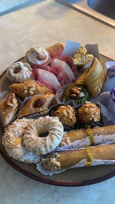 a plate full of assorted donuts and pastries on a counter top,