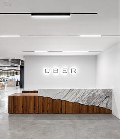 an office lobby with marble counter top and illuminated sign that reads'uber '