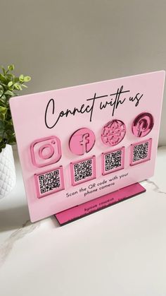 a pink sign that says connect with us and some qr code symbols on it