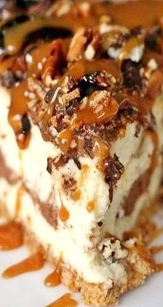 a piece of cheesecake on a plate with caramel sauce and pecans around it