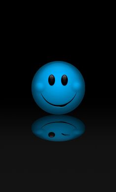 a blue smiley face sitting on top of a black surface