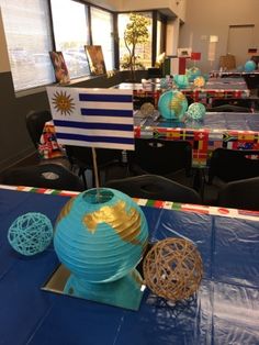tables and chairs are set up for an event with flags on the tablecloths