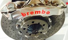 the front brake of a vehicle with an emblem on it's side and red lettering that reads brembo