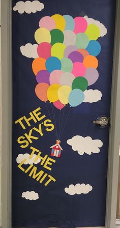 a door decorated with balloons and the words sky's the limit written on it