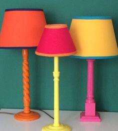 three different colored lamps sitting on top of a table