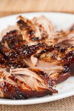 barbecued pork with bbq sauce on a white plate, ready to be eaten