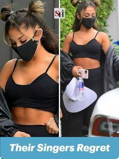 two women in black sports bras wearing face masks and one is holding a cell phone