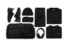 an assortment of black items including headphones, t - shirt, and bag on a white background