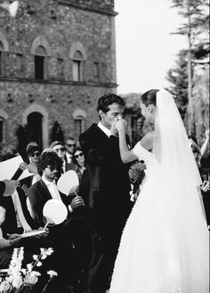 a bride and groom standing in front of an audience