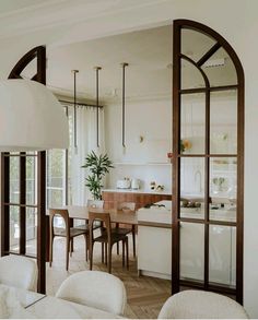 an open kitchen and dining room with arched glass doors