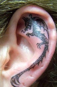 an ear tattoo with a lizard on it