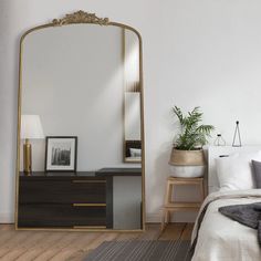 a mirror sitting on top of a dresser next to a bed