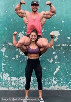 a woman standing on top of a man's shoulders