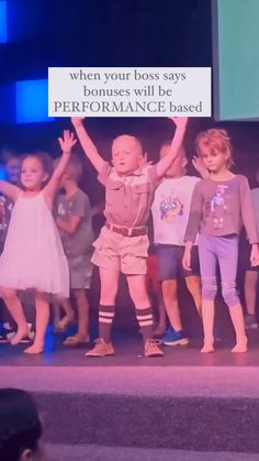 two young children are standing on stage with their arms in the air and one is holding up a sign that says, when your boss says ponies will be performance based
