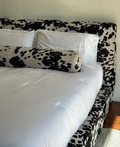 a bed with black and white pillows on it
