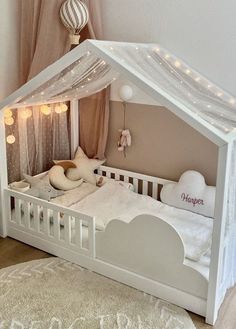 a white doll house bed with lights on the ceiling